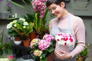 Young happy woman working in the flower shop.