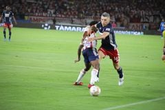 Daniel Torres, volante de Independiente Medellín, disputando una pelota frente a Didier Moreno del Junior