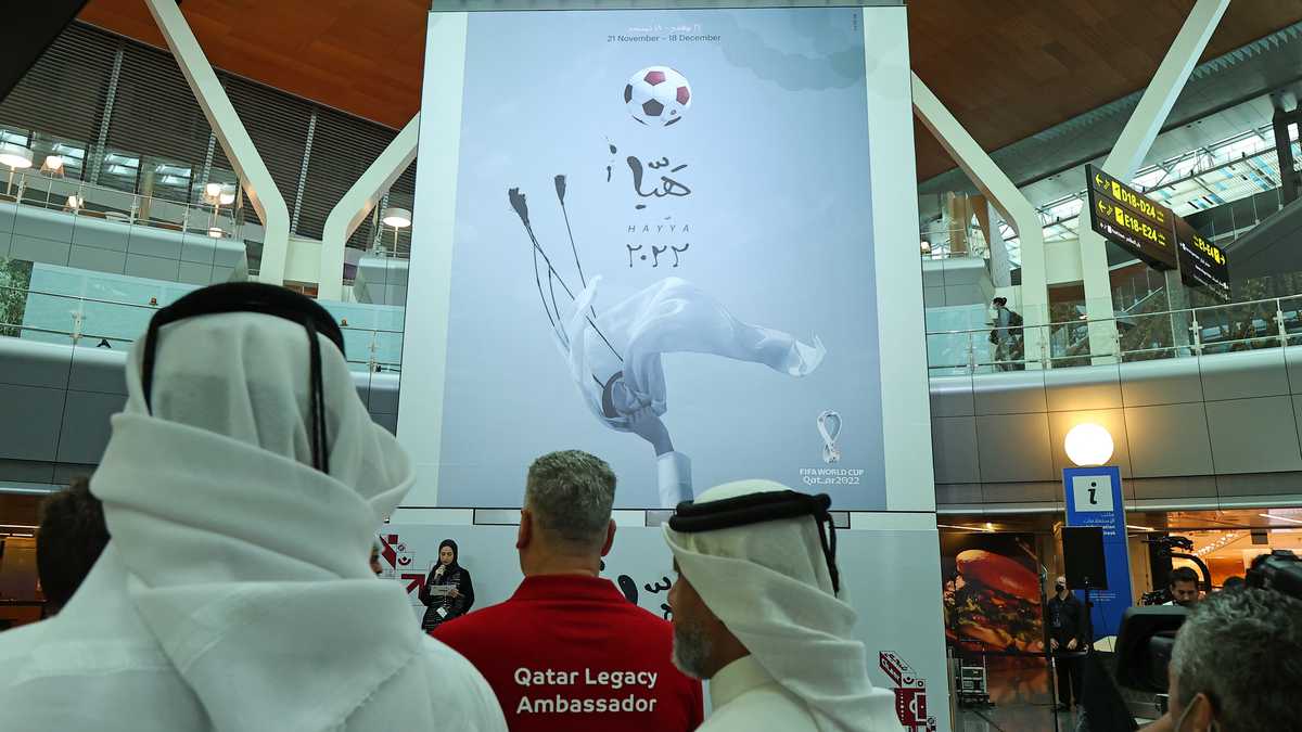 The official poster of Qatar's FIFA World Cup is unveiled at Hamad International Airport in Doha on June 15, 2022. (Photo by KARIM JAAFAR / AFP)