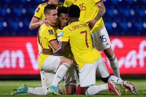 Colombia's Juan Cuadrad, center, is congratulated by teammates after scoring from the penalty spot his side's opening goal against Paraguay during a qualifying soccer match for the FIFA World Cup Qatar 2022 in Asuncion, Paraguay, Sunday, Sept. 5, 2021. (AP Photo/Jorge Saenz)
