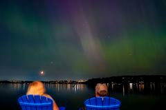 Un grupo de personas admira la aurora boreal que ilumina el lago Washington, en Renton.