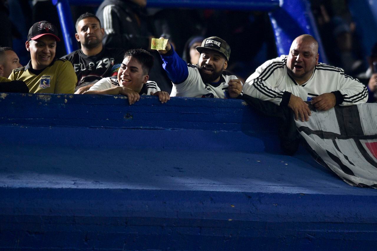 Chile's Colo-Colo fans show Argentine money to Argentina's Boca Juniors fans prior to a Copa Libertadores Group F soccer match in Buenos Aires, Argentina, Tuesday, June 6, 2023. (AP Photo/Gustavo Garello)