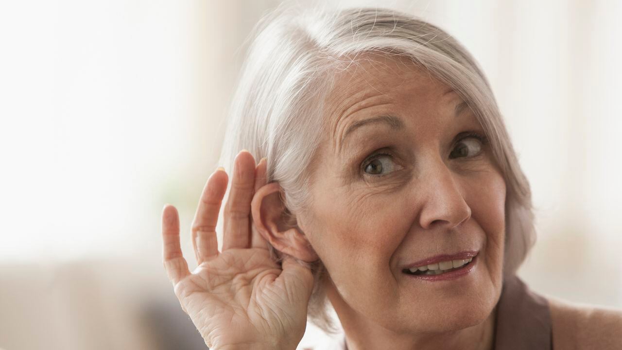 Senior Caucasian woman cupping her ear to listen