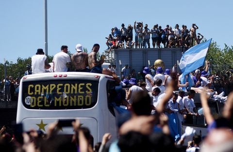 Soccer Football - FIFA World Cup Qatar 2022 - Argentina Victory Parade after winning the World Cup - Buenos Aires, Argentina - December 20, 2022  Argentina fans celebrate as the the bus carrying the players and the World Cup trophy is seen during the victory parade REUTERS/Martin Villar NO RESALES. NO ARCHIVES.