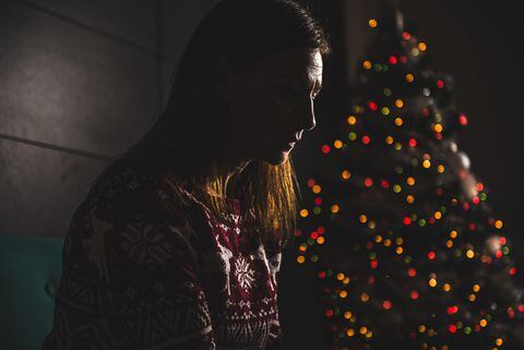 Foto de referencia de una mujer y, de fondo, un árbol de Navidad