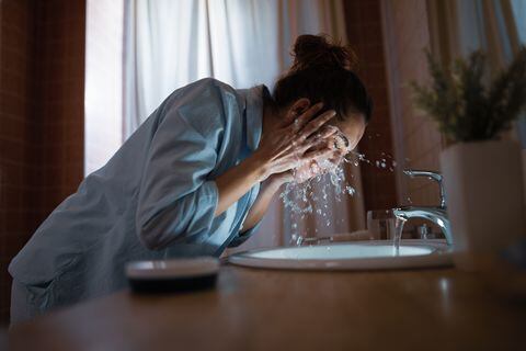 Mujer lavándose la cara.