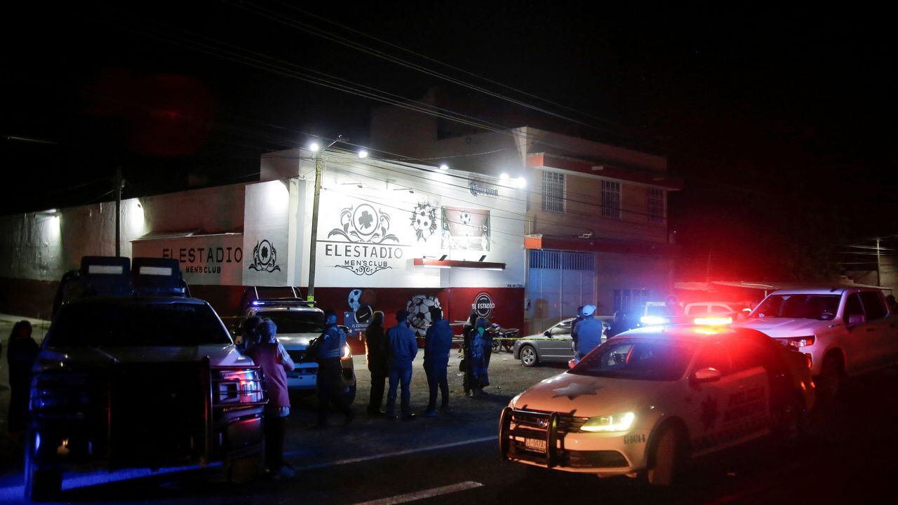 Miembros de las fuerzas de seguridad y transeúntes se encuentran afuera de un club nocturno donde los clientes fueron asesinados y otros heridos por un grupo armado no identificado que abrió fuego contra las personas, en Apaseo El Grande, en el estado de Guanajuato, México