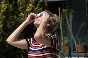 Middle aged woman with special glasses watching the eclipse.