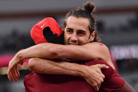 Gold medallists Italy's Gianmarco Tamberi (R) and Qatar's Mutaz Essa Barshim celebrate after the men's high jump final during the Tokyo 2020 Olympic Games at the Olympic Stadium in Tokyo on August 1, 2021. (Photo by Ben STANSALL / AFP) / �The erroneous mention[s] appearing in the metadata of this photo by Ben STANSALL has been modified in AFP systems in the following manner: [Gold medallists] instead of [---]. Please immediately remove the erroneous mention[s] from all your online services and delete it (them) from your servers. If you have been authorized by AFP to distribute it (them) to third parties, please ensure that the same actions are carried out by them. Failure to promptly comply with these instructions will entail liability on your part for any continued or post notification usage. Therefore we thank you very much for all your attention and prompt action. We are sorry for the inconvenience this notification may cause and remain at your disposal for any further information you may require.�