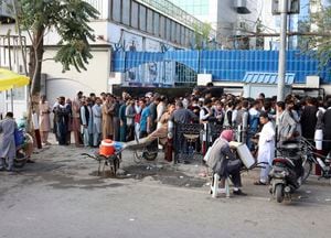 Afganos hacen fila para tratar de retirar dinero frente a un banco de Kabul, Afganistán, el lunes 30 de agosto de 2021. (AP Foto/Khwaja Tawfiq Sediqi)