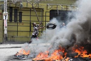 Manifestante arroja un neumático a una barricada en llamas durante las protestas que exigen que el gobierno del primer ministro Ariel Henry haga más para abordar la violencia de las pandillas, incluidos los secuestros constantes, en Puerto Príncipe, Haití, el 29 de marzo de 2022. Foto REUTERS/Ralph Tedy Erol