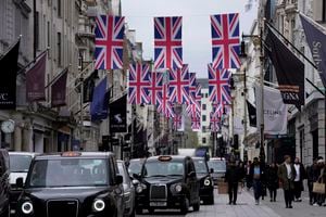 Union flags are raised to celebrate the upcoming coronation of King Charles III, in central London, Wednesday, April 26, 2023. (AP Photo/Kin Cheung)