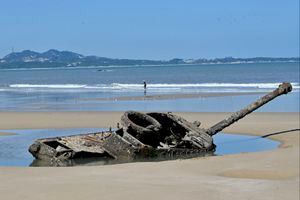 The rusted out wreckage of an old tank is seen at Ou Cuo Sandy Beach on Taiwan's Kinmen islands, which lie just 3.2 kms (two miles) from the mainland China coast, on August 11, 2022. (Photo by Sam Yeh / AFP)
