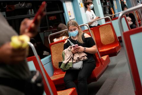 Una mujer joven con mascarilla usa su celular en un tren del metro en Lisboa, Portugal. (AP Foto/Armando Franca)