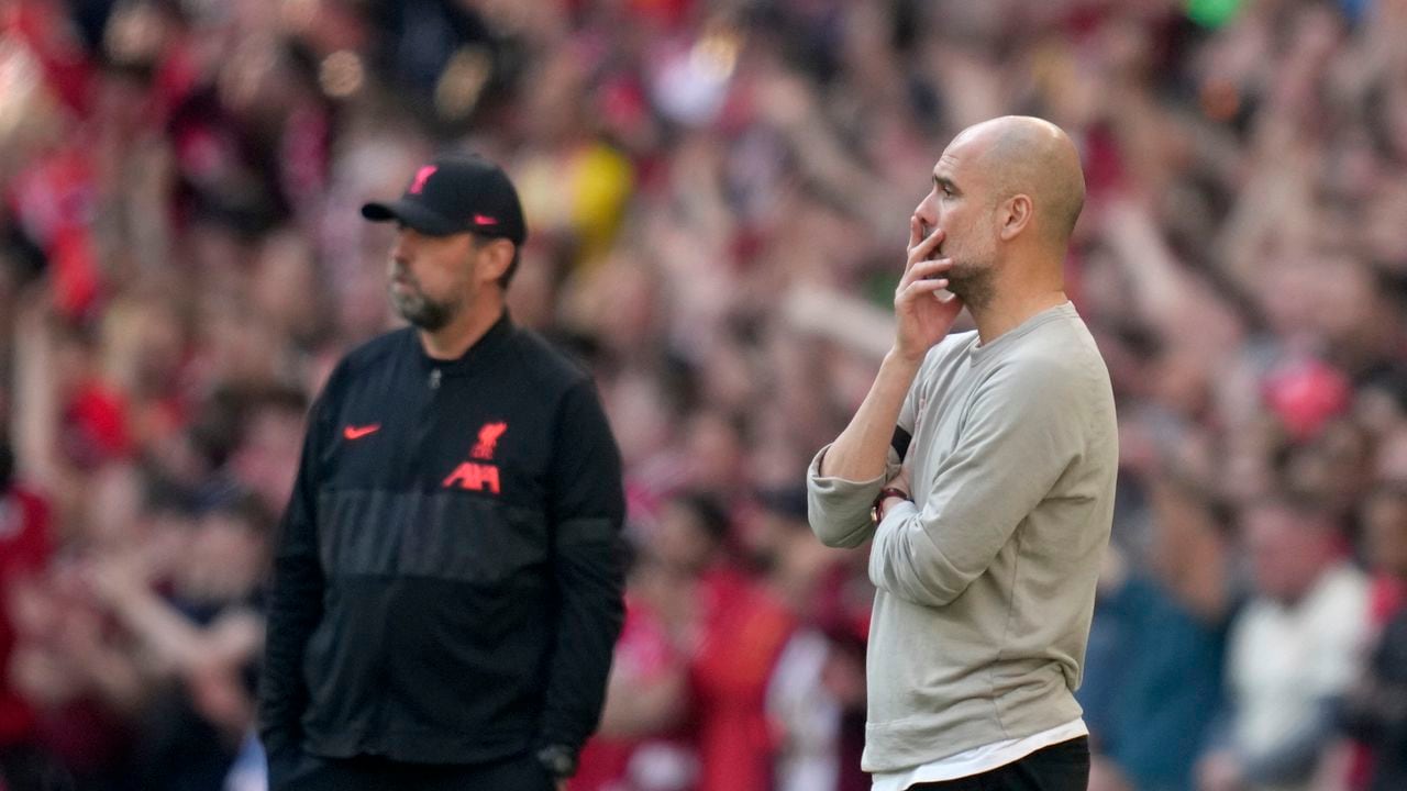 Manchester City's head coach Pep Guardiola and Liverpool's manager Jurgen Klopp, left, stand by the touchline during the English FA Cup semifinal soccer match between Manchester City and Liverpool at Wembley stadium in London, Saturday, April 16, 2022. (AP Photo/Kirsty Wigglesworth)