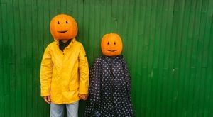 Photo of a couple with pumpkins on the heads, ready for the Halloween.