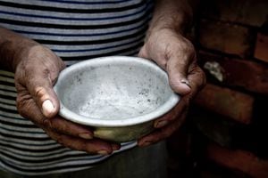 The poor old man's hands hold an empty bowl. The concept of hunger or poverty. Selective focus. Poverty in retirement. Homeless. Alms