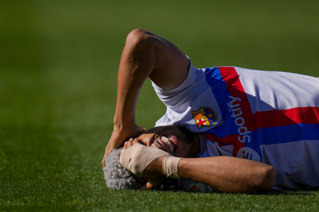 Barcelona's Ronald Araujo grimaces in pain after a tackle during a Spanish La Liga soccer match between Getafe and FC Barcelona at the Coliseum Alfonso Perez stadium in Getafe, Spain, Sunday, April 16, 2023. (AP Photo/Manu Fernandez)
