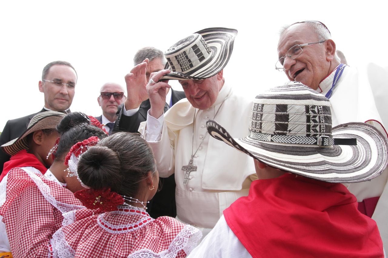 El papa Francisco se prueba el sombrero vueltiao que le obsequiaron las niñas y niños que lo esperaban en el aeropuerto de Cartagena.