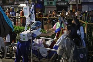 Los residentes y el personal médico evacuan a los pacientes desde el interior de un hospital después de que un terremoto de 7,6 sacudiera la ciudad de Butuan