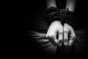 Hands of a missing kidnapped, abused, hostage, victim woman tied up with rope in emotional stress and pain, afraid, restricted, trapped, call for help, struggle, terrified, locked in a cage cell.