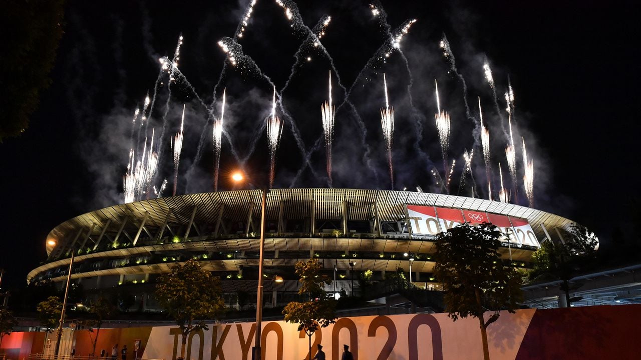 Los fuegos artificiales estallan alrededor del Estadio Olímpico durante la ceremonia de clausura de los Juegos Olímpicos de Tokio 2020, visto desde fuera de la sede en Tokio el 8 de agosto de 2021 (Foto de Kazuhiro NOGI / AFP).
