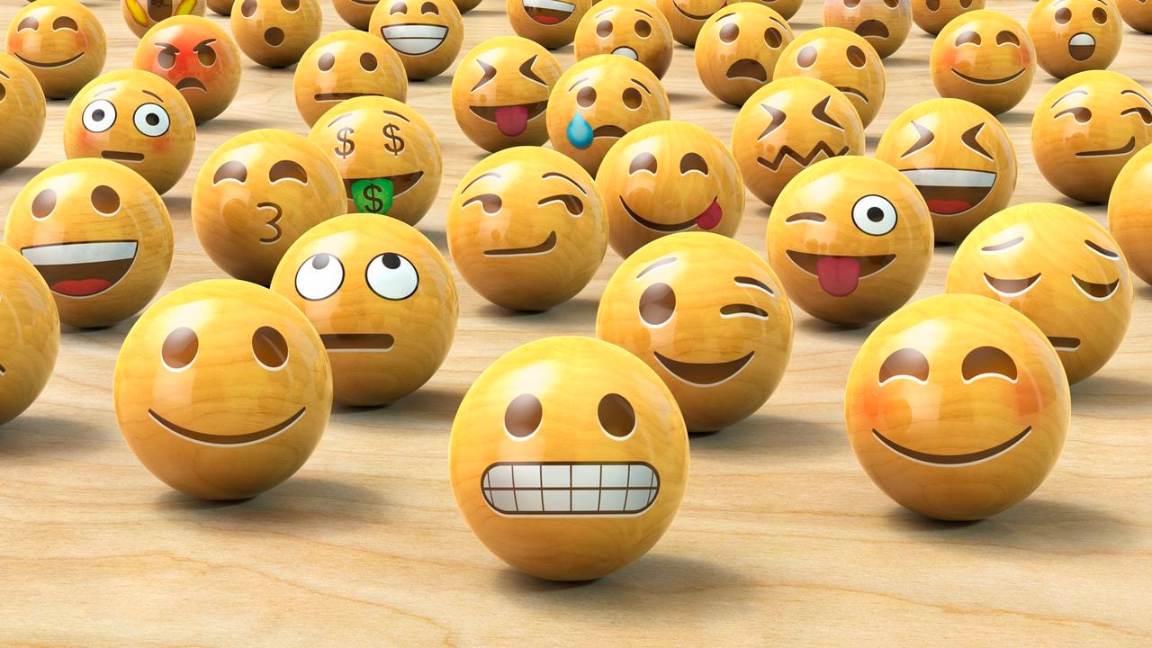 Muchos emoticonos de madera o bolas de cara de Emoji, una al frente