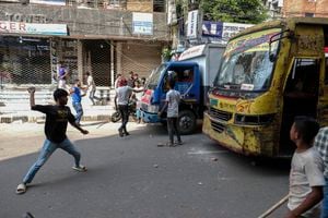Trabajadores de la confección de Bangladesh destrozan autobuses durante una protesta exigiendo un aumento de sus salarios en Mirpur en Dhaka, Bangladesh, el martes 31 de octubre de 2023. (Foto AP/Mahmud Hossain Opu)