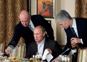 FILE PHOTO: Yevgeny Prigozhin (L) assists Russian Prime Minister Vladimir Putin during a dinner with foreign scholars and journalists at the restaurant Cheval Blanc on the premises of an equestrian complex outside Moscow November 11, 2011. Picture taken November 11.  REUTERS/Misha Japaridze/Pool/File Photo/File Photo