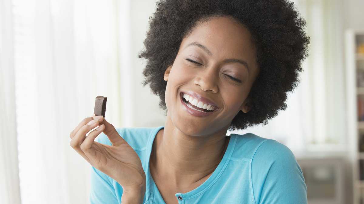 Mujer feliz comiendo chocolate