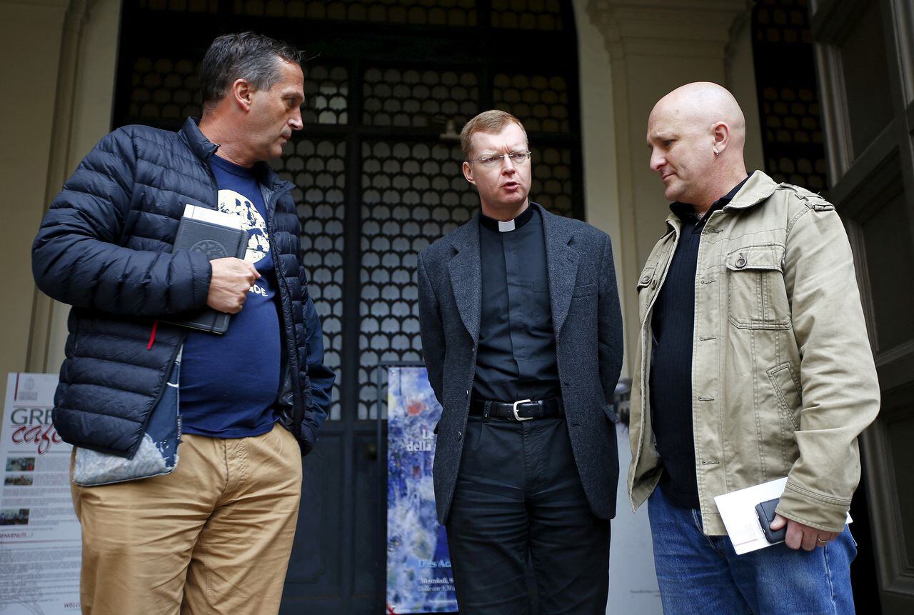 FILE PHOTO: Father Hans Zollner (C) talks with Andrew Collins (R) and David Ridsdale, who said they were child sex abuse victims, at the end of a meeting at the Gregoriana University in Rome, Italy, March 3, 2016. Cardinal George Pell said on Wednesday he should have done more to stop the sexual abuse of children in the Catholic Church, acknowledging that he was told of at least one priest "misbehaving" with boys at an Australian school. REUTERS/Tony Gentile/File Photo