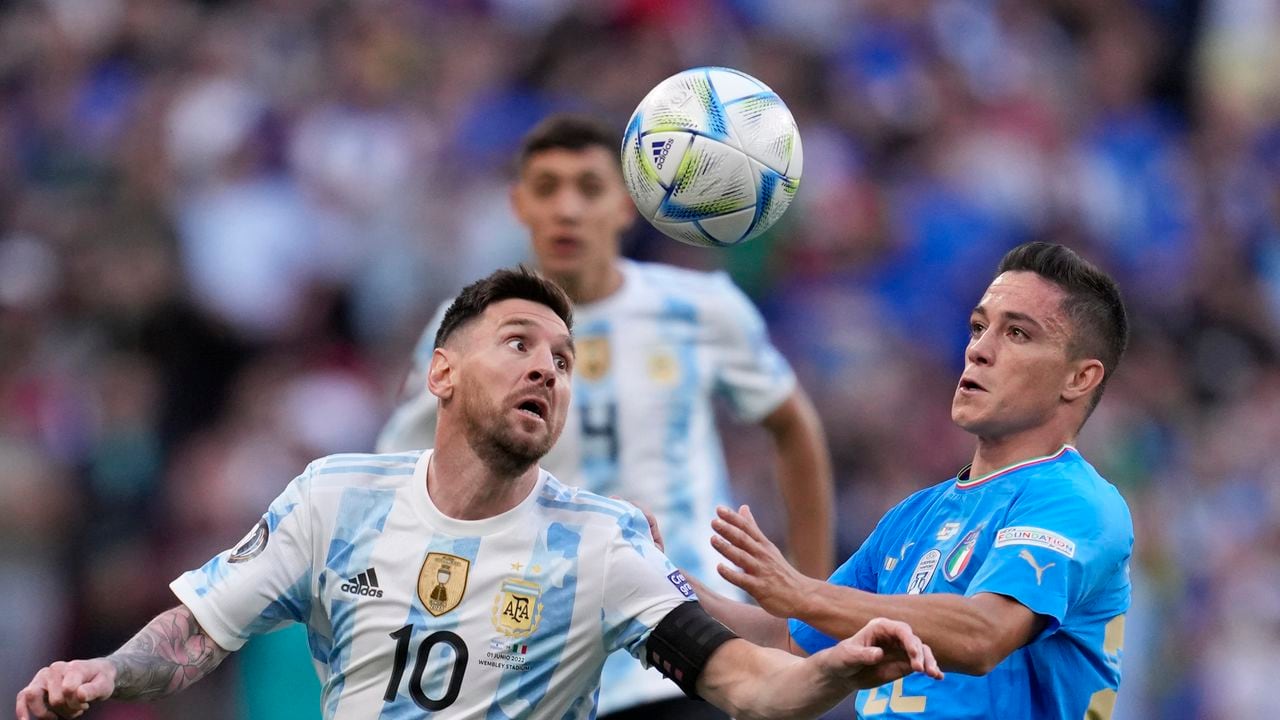 Argentina's Lionel Messi, left, challenges for the ball with Italy's Giacomo Raspadori during the Finalissima soccer match between Italy and Argentina at Wembley Stadium in London , Wednesday, June 1, 2022. (AP Photo/Matt Dunham)