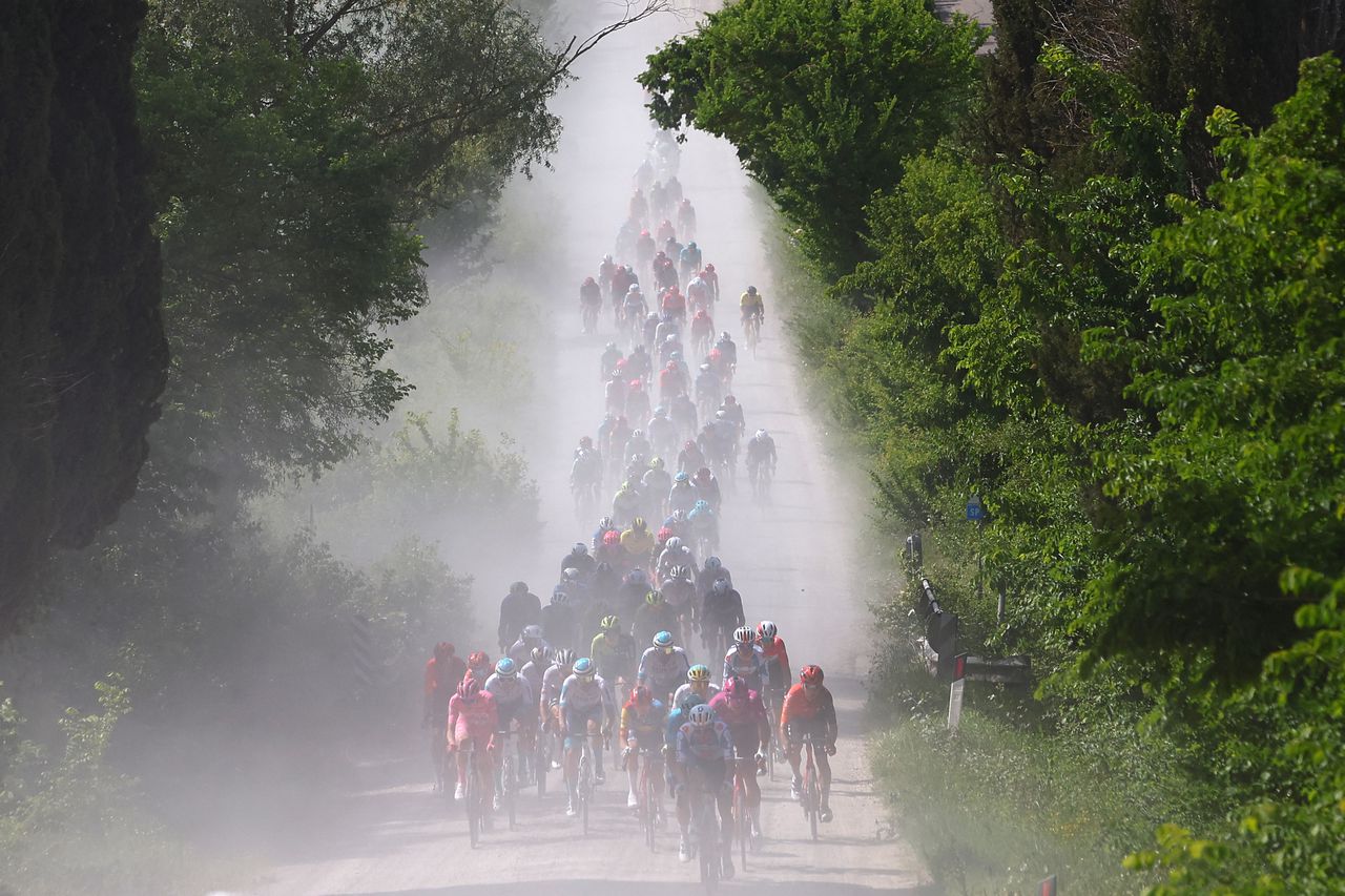 The pack rides on white roads of Tuscany during the 6th stage of the 107th Giro d'Italia cycling race, 180 km between Torre del lago Puccini and Rapolano Terme, on May 9, 2024. (Photo by Luca Bettini / AFP)