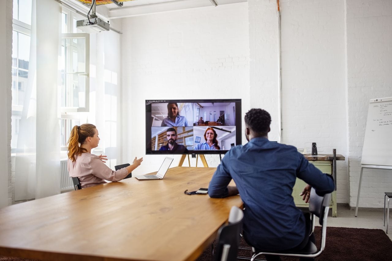 Empresarios con una videoconferencia en la oficina. Hombres y mujeres de negocios que tienen una conferencia web en la sala de juntas de la oficina.