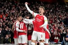 Arsenal's Martin Odegaard, center, celebrates after Bukayo Saka scored the opening goal during the Champions League quarter final first leg soccer match between Arsenal and Bayern Munich at the Emirates Stadium, London, Tuesday, April 9, 2024. (AP Photo/Frank Augstein)