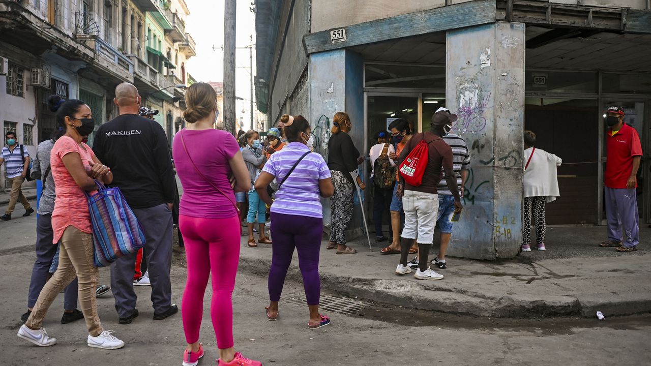 En medio de un pesado sol, cubanos se mantienen en las filas para acceder a bienes básicos. (Photo by Yamil LAGE / AFP)