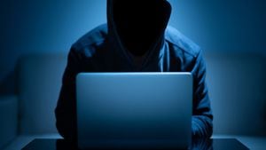 Cara oscura del hacker que usa la computadora portátil en el cuarto oscuro