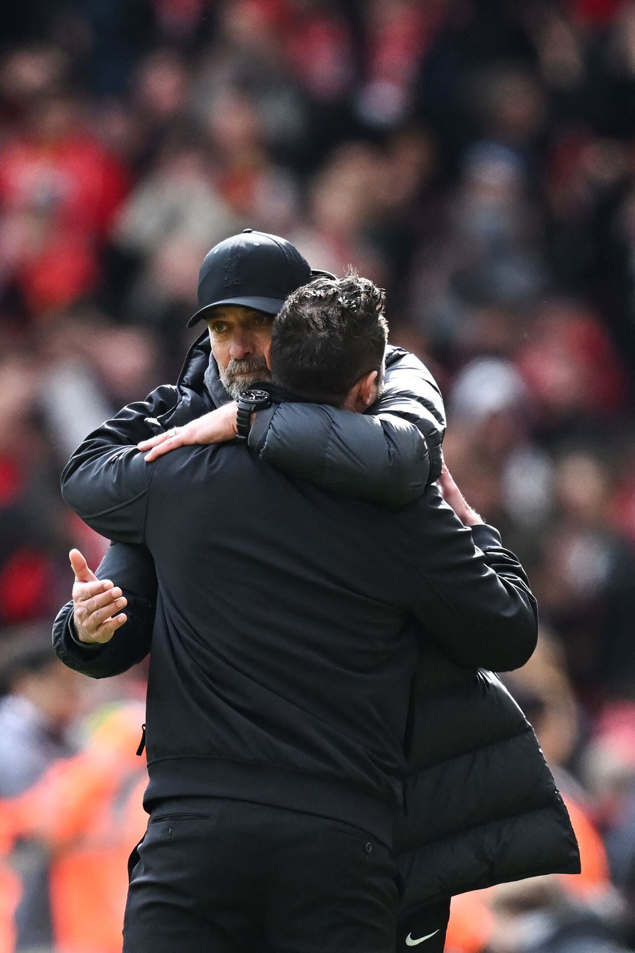 Liverpool's German manager Jurgen Klopp (rear) hugs Brighton's Italian head coach Roberto De Zerbi at the end of the English Premier League football match between Liverpool and Brighton and Hove Albion at Anfield in Liverpool, north west England on March 31, 2024. Liverpool wins 2 - 1 against Brighton and Hove Albion. (Photo by Paul ELLIS / AFP) / RESTRICTED TO EDITORIAL USE. No use with unauthorized audio, video, data, fixture lists, club/league logos or 'live' services. Online in-match use limited to 120 images. An additional 40 images may be used in extra time. No video emulation. Social media in-match use limited to 120 images. An additional 40 images may be used in extra time. No use in betting publications, games or single club/league/player publications. /