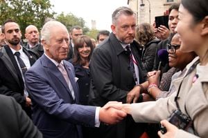 Britain's King Charles III meets residents after visiting the Flower Market Thursday, Sept. 21, 2023 in Paris. The royal couple's trip started Wednesday with a ceremony at Arc de Triomphe in Paris and a state dinner at the Palace of Versailles. King Charles will rejoin French President Emmanuel Macron in front of Notre-Dame Cathedral to see the ongoing renovation work aimed at reopening the monument by the end of next year, after it was devastated by a fire in 2019.(AP Photo/Christophe Ena; Pool)