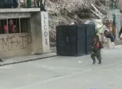 El niño viste uniforme del grupo al margen de la ley mientras porta un fusil de juguete.