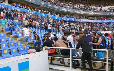 Supporters of Atlas fight with supporters of Queretaro during the Mexican Clausura tournament football match between Queretaro and Atlas at Corregidora stadium in Queretaro, Mexico on March 5, 2022. - A match between Mexican football clubs was called off March 5, 2022 after violence by opposing fans spilled onto the field. The game between Queretaro and Atlas at La Corregidora stadium in the city of Queretaro  -- the ninth round of the 2022 Clausura football tournament -- was in its 63rd minute when fights between opposing fans broke out. (Photo by EDUARDO GOMEZ / AFP)