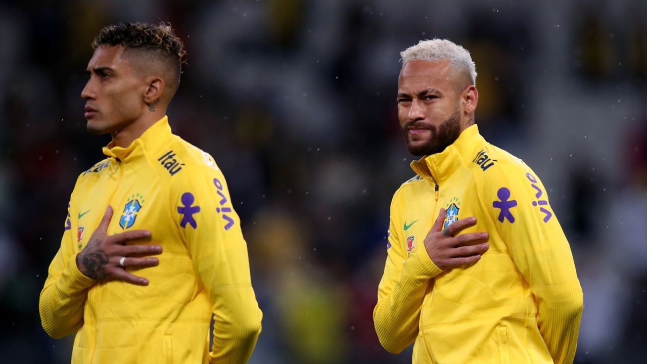 SAO PAULO, BRAZIL - NOVEMBER 11: (L-R) Raphinha and Neymar Jr. of Brazil line up for the national anthem prior to a match between Brazil and Colombia as part of FIFA World Cup Qatar 2022 Qualifiers at Neo Quimica Arena on November 11, 2021 in Sao Paulo, Brazil. (Photo by Getty Images/Alexandre Schneider)