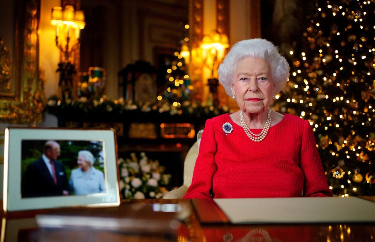 Una imagen publicada el 23 de diciembre de 2021 muestra a la reina Isabel II de Gran Bretaña posando para una fotografía mientras grababa su mensaje anual del día de Navidad, con una fotografía de ella y de su difunto esposo, el príncipe Felipe de Gran Bretaña, duque de Edimburgo, tomada en 2007 en Broadlands, para marcan su aniversario de bodas de diamantes, en el White Drawing Room del Castillo de Windsor, al oeste de Londres