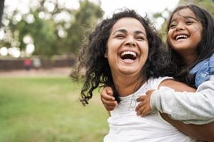 Feliz madre india divirtiéndose con su hija al aire libre - Concepto de familia y amor - Enfoque en la cara de mamá
