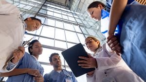 Grupo de trabajadores de la salud latinoamericanos hablando en una reunión en el hospital y mirando algunos resultados de pruebas en una tableta: conceptos de salud y medicina. **EL DISEÑO EN LAS ETIQUETAS DE NOMBRE NOS PERTENECE**