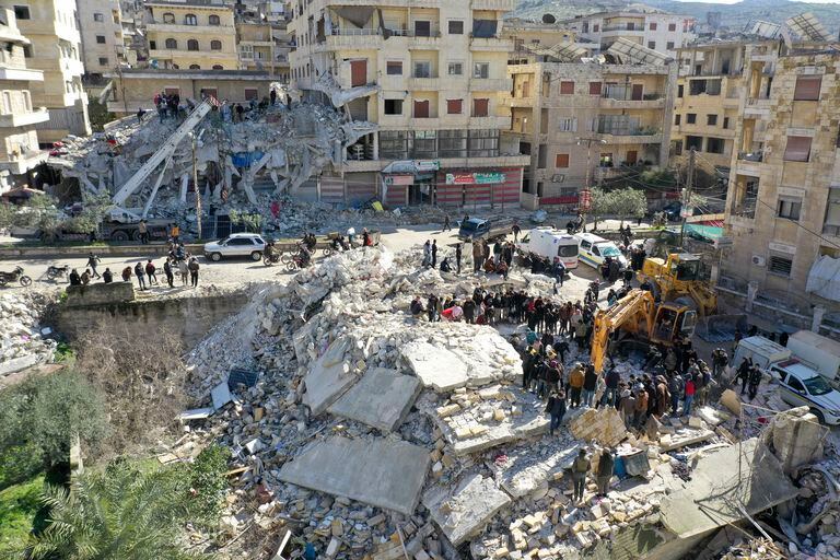 An aerial picture shows rescuers searching the rubble of buildings for casualties and survivors in the village of Salqin in Syria's rebel-held northwestern Idlib province at the border with Turkey  following an earthquake, on February 7, 2023. (Photo by Omar HAJ KADOUR / AFP)