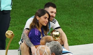 Soccer Football - FIFA World Cup Qatar 2022 - Final - Argentina v France - Lusail Stadium, Lusail, Qatar - December 18, 2022 Argentina's Lionel Messi celebrates winning the World Cup with wife Antonela Roccuzzo holding the trophy REUTERS/Molly Darlington
