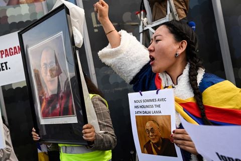 Una mujer sostiene un cartel que dice "Estamos con su santidad, el decimocuarto Dalai Lama".