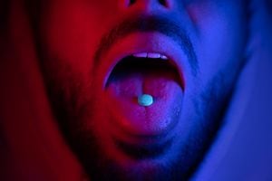 Close up of man mouth swallowing ecstasy drugs. Man taking MDMA ecstasy pill. High quality 4k footage