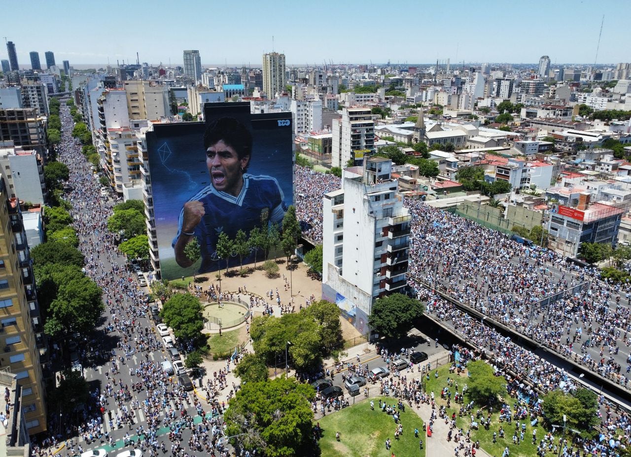 Soccer Football - FIFA World Cup Qatar 2022 - Argentina Victory Parade after winning the World Cup - Buenos Aires, Argentina - December 20, 2022  A mural of Diego Maradona is seen with Argentina fans during the victory parade REUTERS/Agustin Marcarian